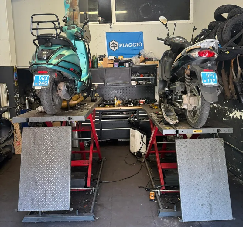 Twee scooters op de hefbruggen in de werkplaats, gereedschap binnen handbereik